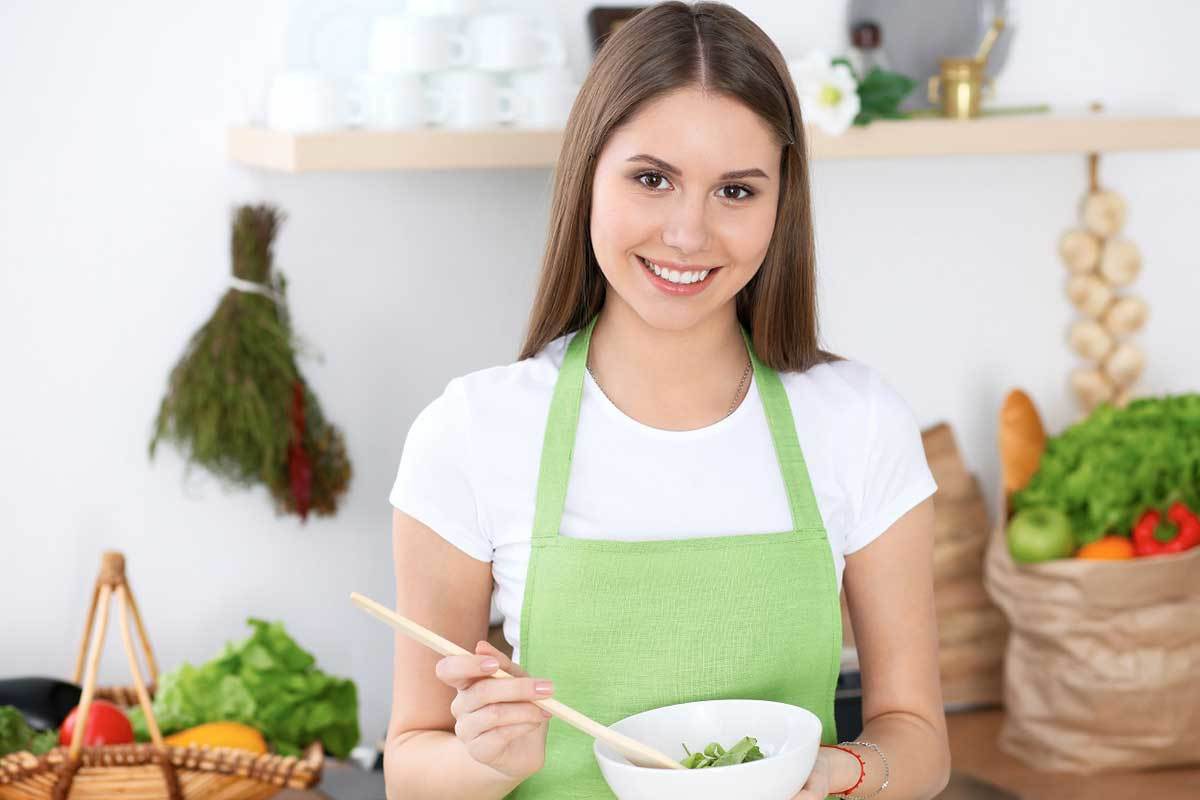 woman cooking green vegetables