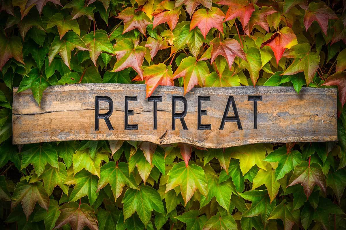 wooden sign with the word retreat carved into it